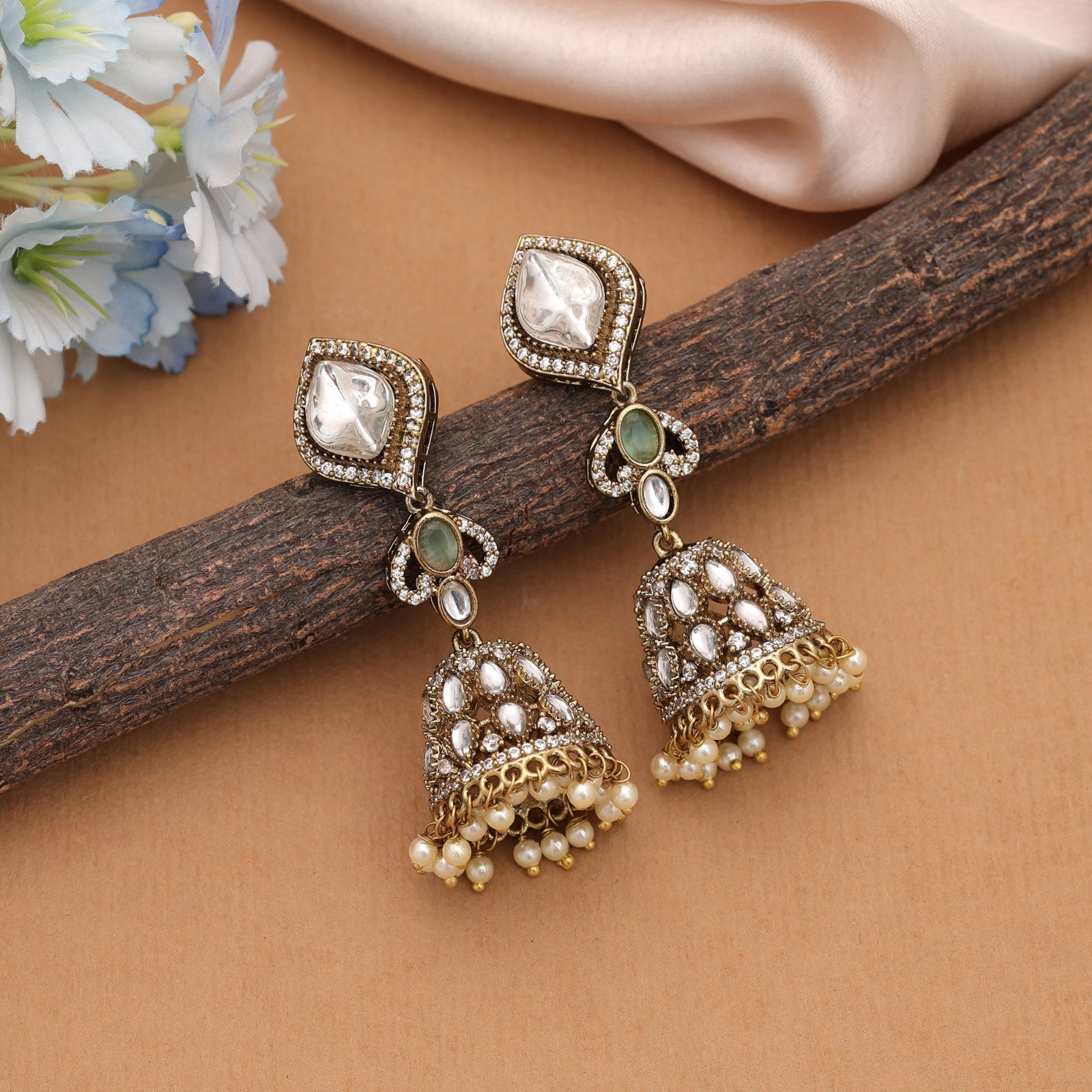 Pair of antique gold statement jhumka earrings featuring diamond-shaped Kundan studs, oval mint green Monalisa stones, and pearl-edged dome drops.