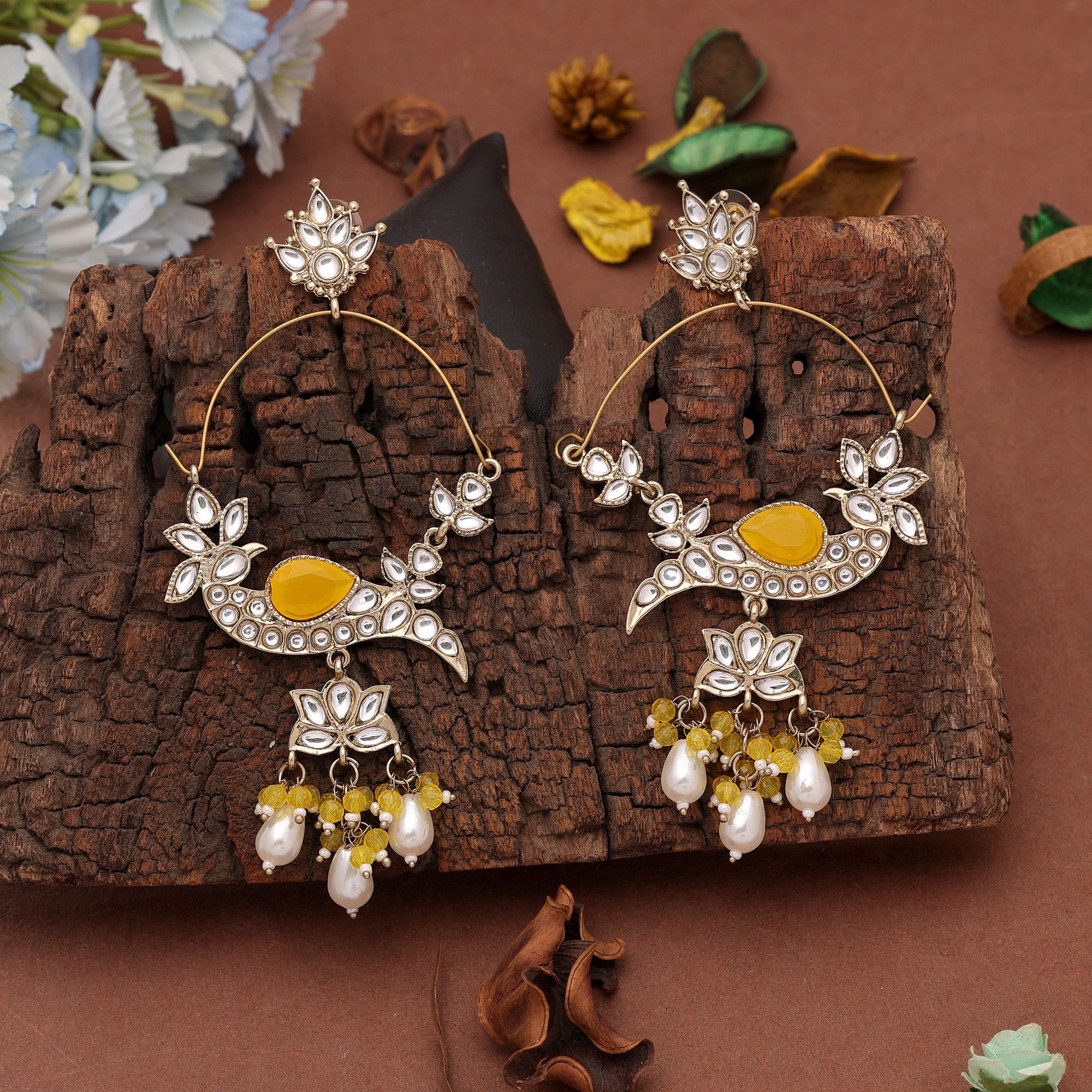 A pair of oversized antique gold-plated hoop chandbali earrings adorned with multi-shaped Kundan stones, a large central faceted gemstone, and a dangling fringe of tiny black micro-beads paired with smooth white pearl droplets.