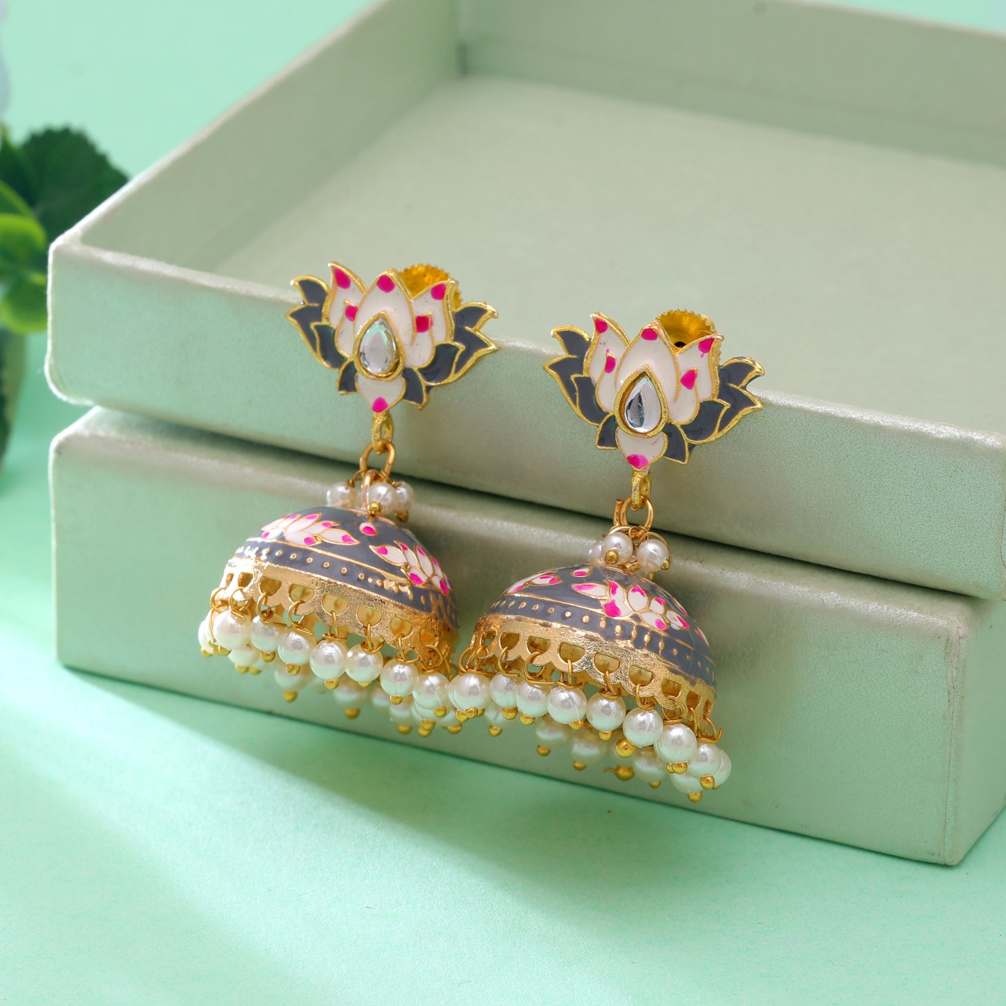 A pair of traditional gold-plated sky blue Meenakari jhumka earrings featuring an upper stud shaped like a blooming lotus flower with white and pink petals, a bell-shaped dome detailed with lotus blossoms and gold vines, and a lower fringe of dangling white faux pearl drops.