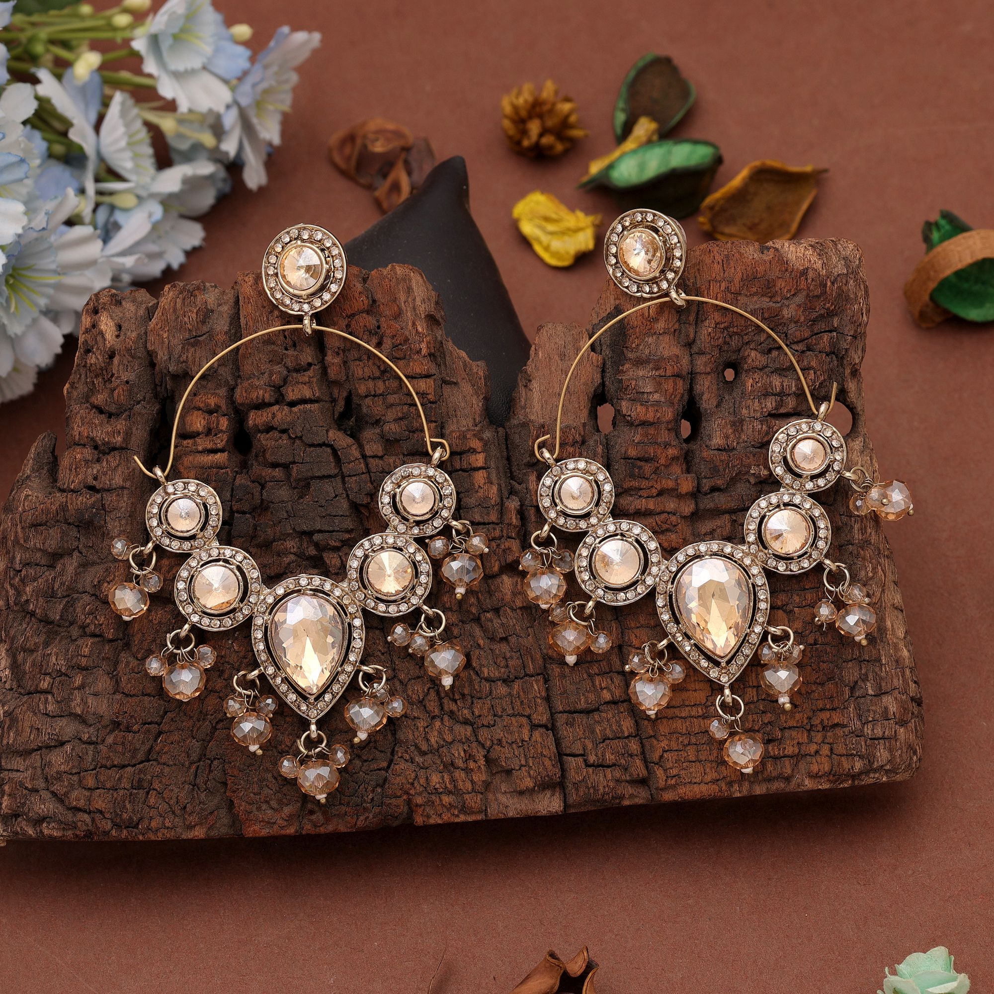 An elegant pair of champagne gold hoop chand bali earrings decorated with multi-shaped glass stones, textured gold borders, and delicate dangling faceted champagne glass beads.