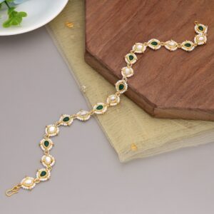 A traditional gold-plated Indian bridal matha patti hair chain featuring alternating teardrop-shaped emerald green stones and clear white Kundan crystals, framed by an intricate outline of tiny white seed beads and finished with a gold s-hook closure.
